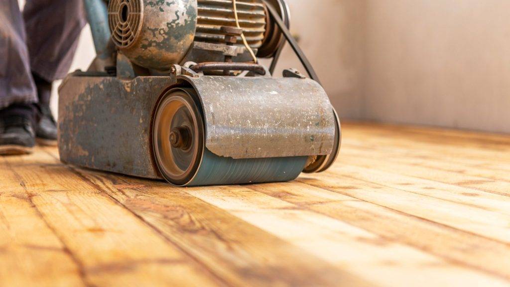 Professional floor sanding machine smoothing a wooden floor. 